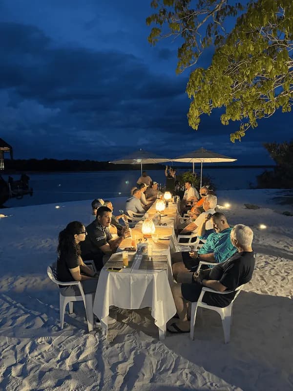 Group enjoying a shared meal beside the river